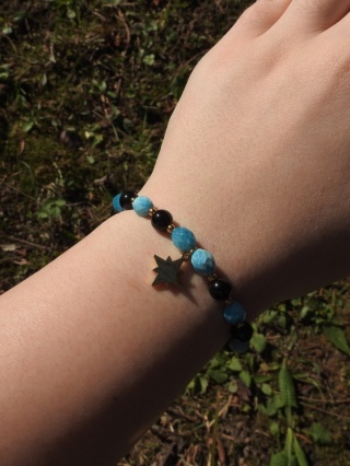 Bransoletka na gumce z apatytami, onyksami i zawieszką różą wiatrów ze stali chirurgicznej w kolorze złotym